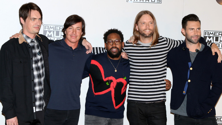 Les membres de Maroon 5 posant ensemble et souriant