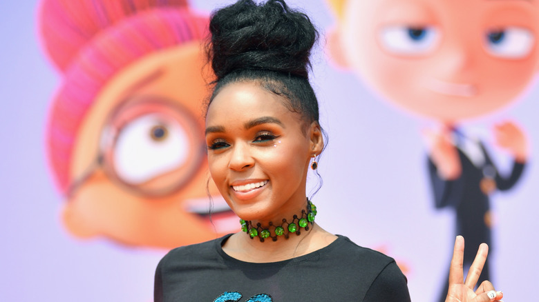 Janelle Monae posant lors d'un événement avec un signe de paix