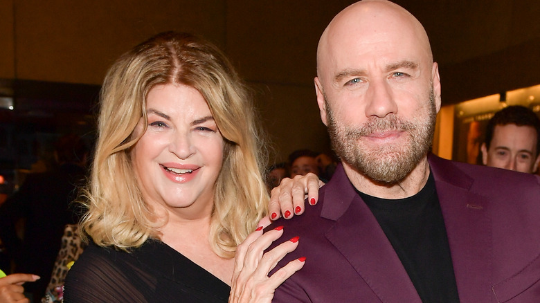 Kirstie Alley sourit avec ses mains sur l'épaule de John Travolta