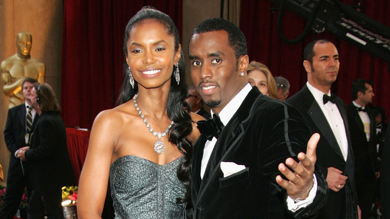 Kim Porter souriant, Diddy avec son bras tendu