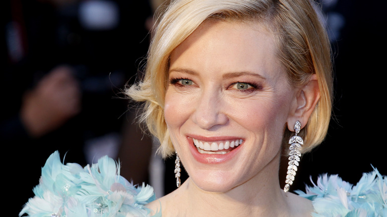 Cate Blanchett avec des boucles d'oreilles en forme de feuille, souriante