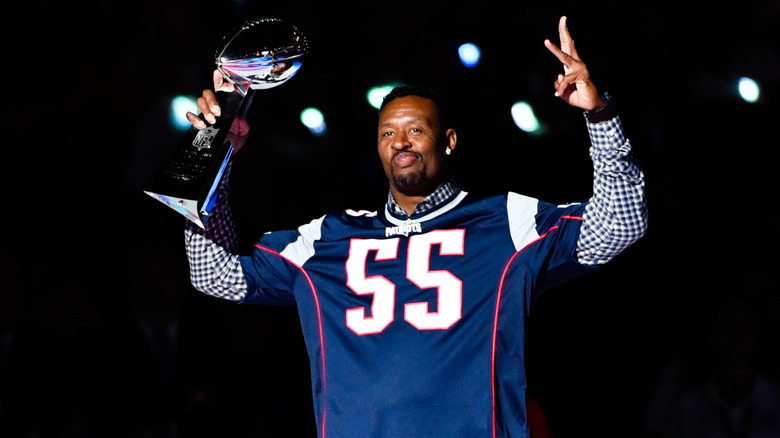 Willie McGinest détient le trophée Vince Lomabrdi 