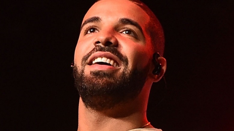 Drake sourit et lève les yeux alors qu'il se produit sur scène