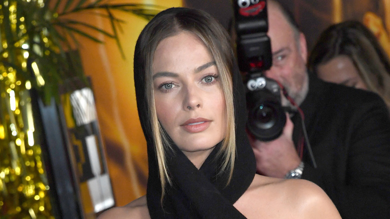 Margot Robbie posant dans une écharpe à capuche