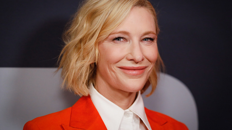 Cate Blanchett souriante en tailleur orange