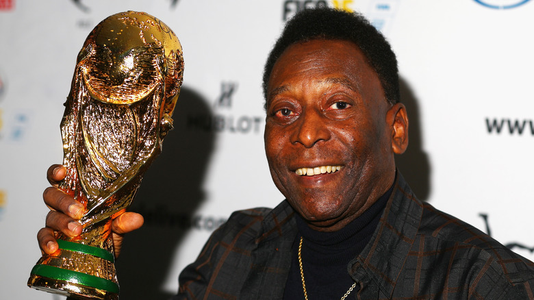 Pelé brandissant un trophée de la Coupe du monde