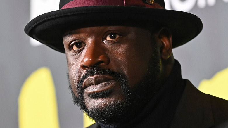 Shaquille O'Neal porte un chapeau, un col roulé et un blazer