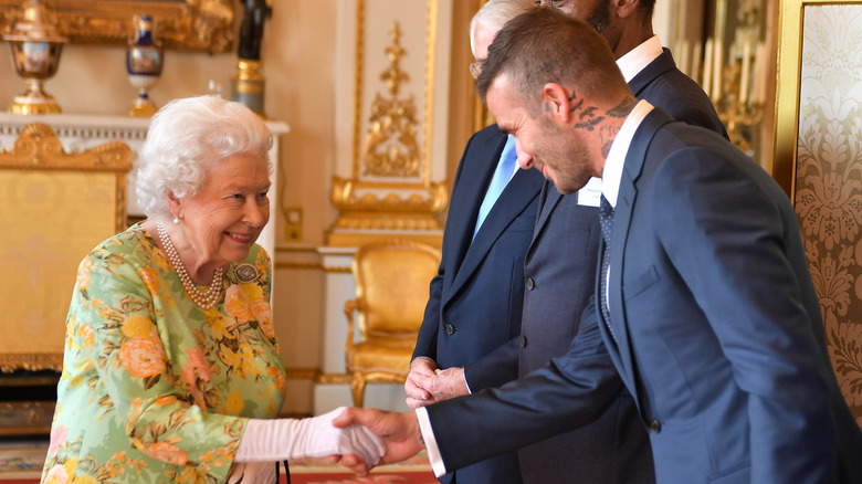 David Beckham tenant la main de la reine Elizabeth II