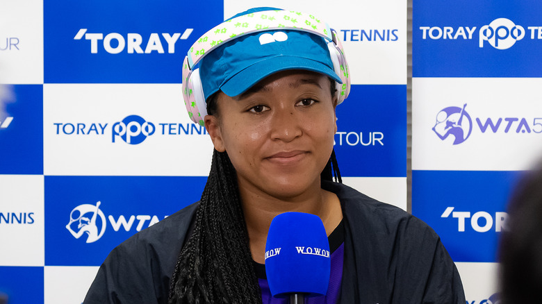 Naomi Osaka tenant un micro