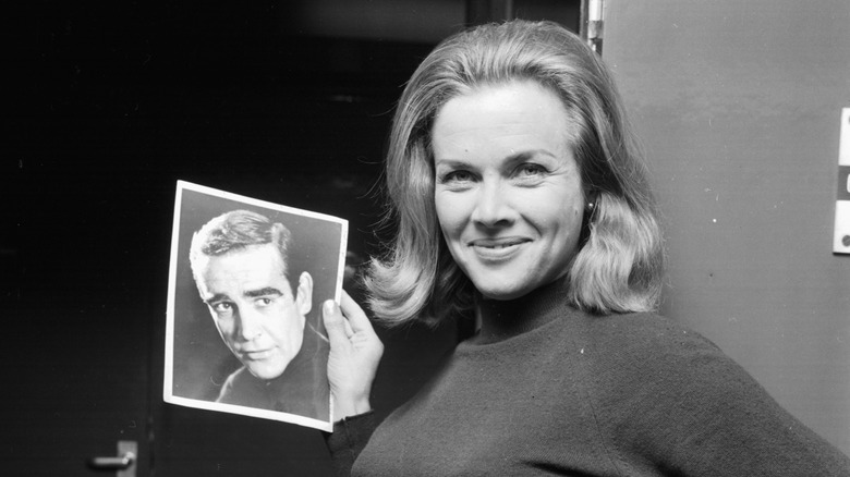 Honor Blackman posant avec une photo de Sean Connery