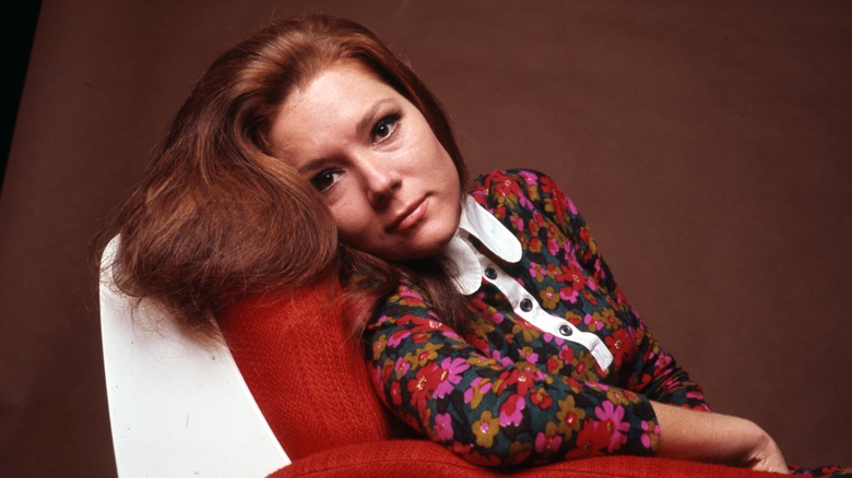 Diana Rigg posant sur une chaise