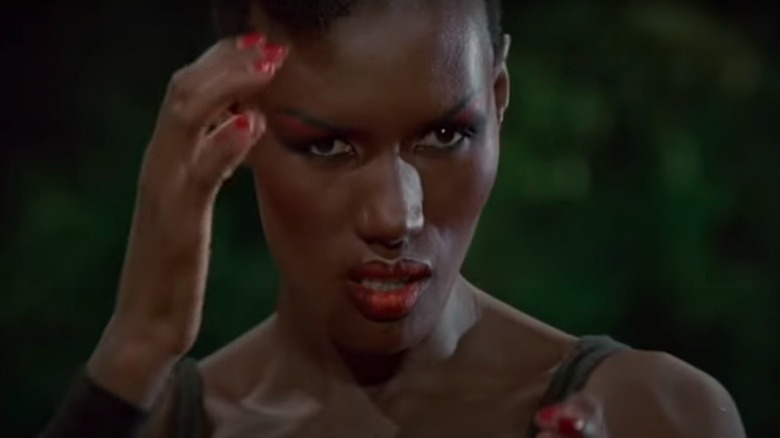 Grace Jones a l'air féroce, la main posée sur la tempe