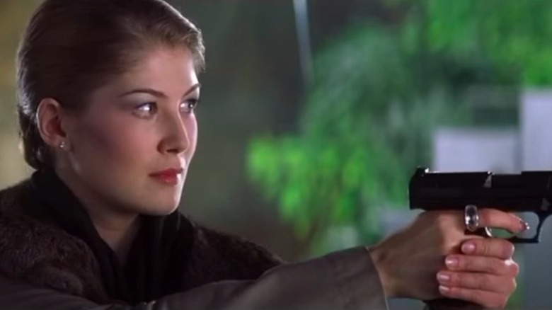 Rosamind Pike tenant une arme à feu