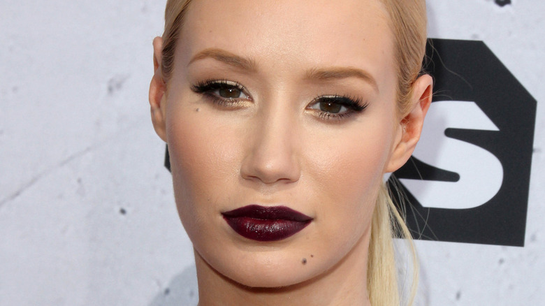 Iggy Azalea posant en rouge à lèvres foncé