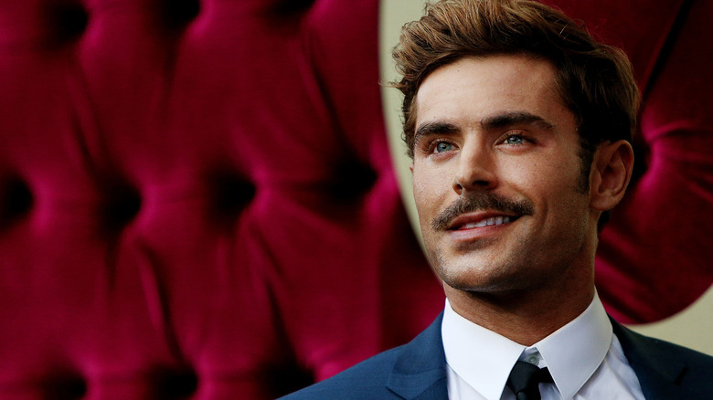 Zac Efron souriant, levant les yeux