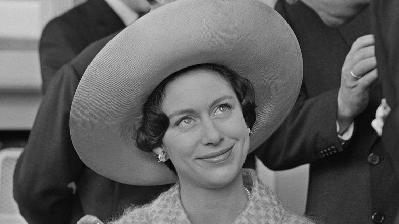 La princesse Margaret lors d'un événement portant un grand chapeau et souriant