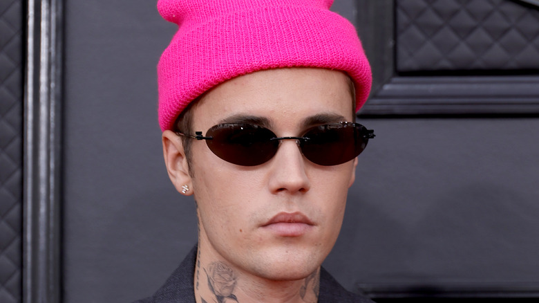 Justin Bieber portant des lunettes de soleil et un bonnet rose