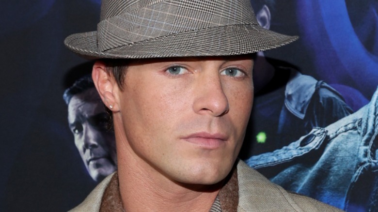 Colton Haynes portant un chapeau sur le tapis rouge Teen Wolf, regardant la caméra