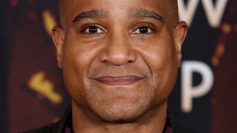 Seth Gilliam souriant fond rouge