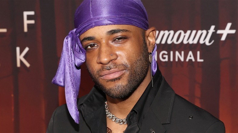 Khylin Rhambo violet do-rag fond rouge, doux sourire