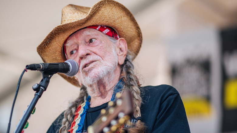 Willie Nelson chantant chapeau de paille cheveux tressés