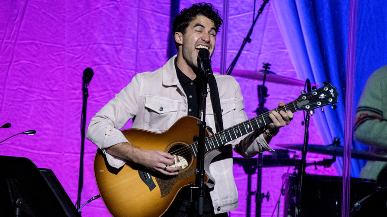 Darren Criss joue de la guitare et chante