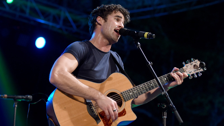 Darren Criss chantant et jouant de la guitare 