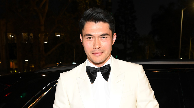 Henry Golding posant en smoking