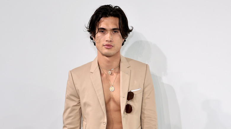 Charles Melton posant en costume sans chemise