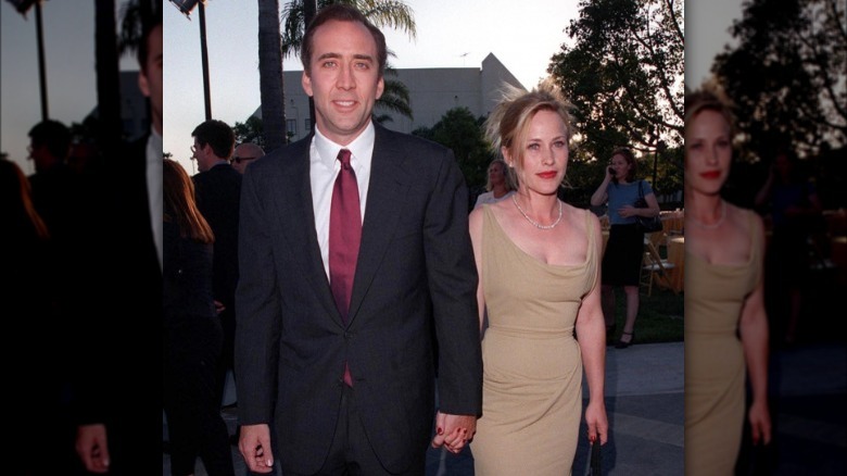 Nicolas Cage et Patricia Arquette se tiennent la main sur un tapis rouge