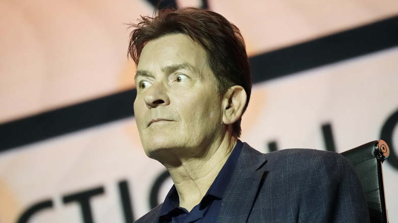 Charlie Sheen regarde au loin, les yeux écarquillés