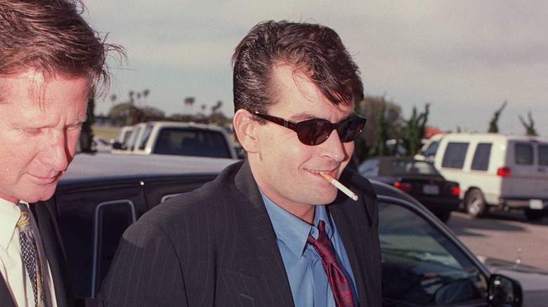 Charlie Sheen souriant, cigarette à la bouche