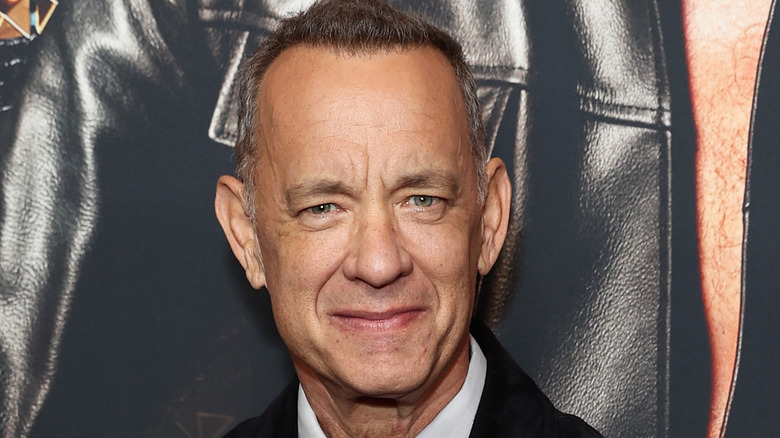 Tom Hanks souriant doucement à la caméra