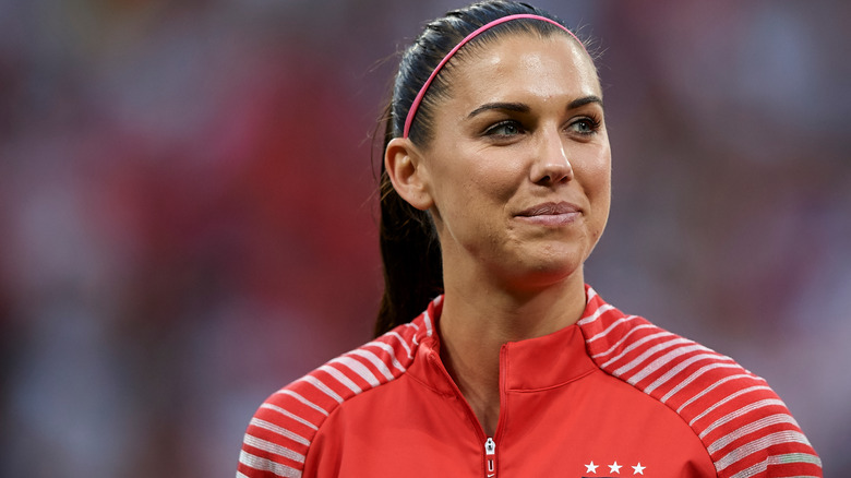 Alex Morgan regarde ailleurs, souriant