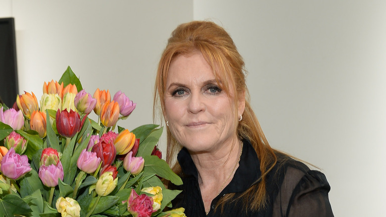 Sarah Ferguson posant à côté de fleurs