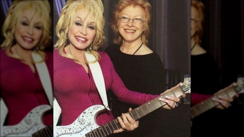 Dolly Parton et Judy Ogle souriant avec une guitare