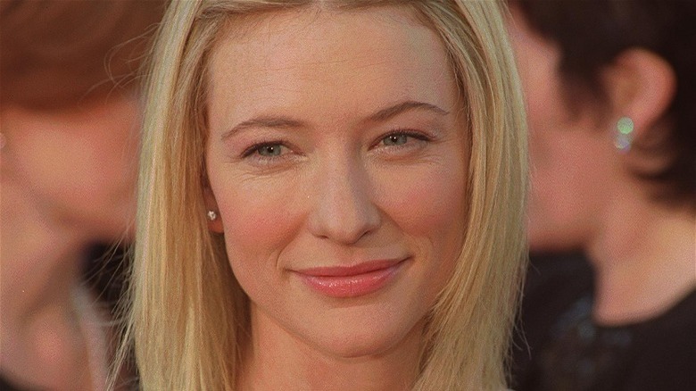 Une jeune Cate Blanchett souriante, cheveux blonds