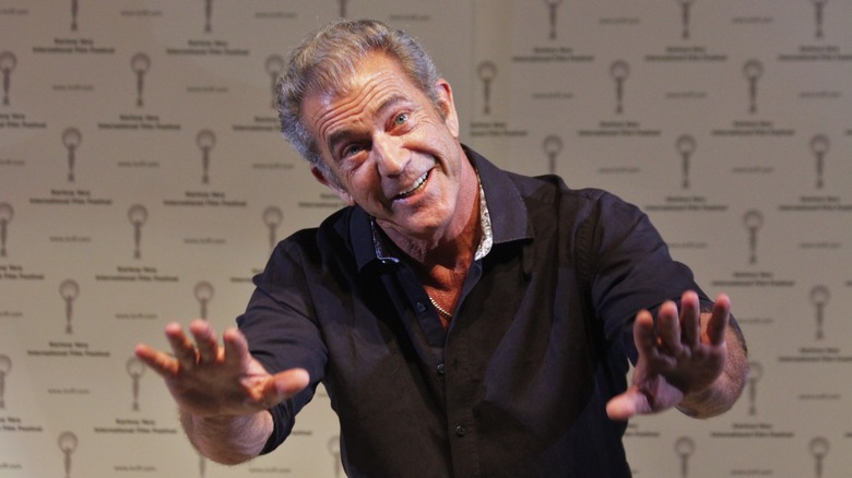 Mel Gibson souriant en tendant les mains