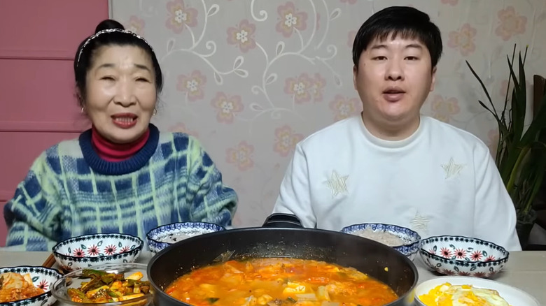 Un couple d'amoureux assis à table avec leur nourriture.