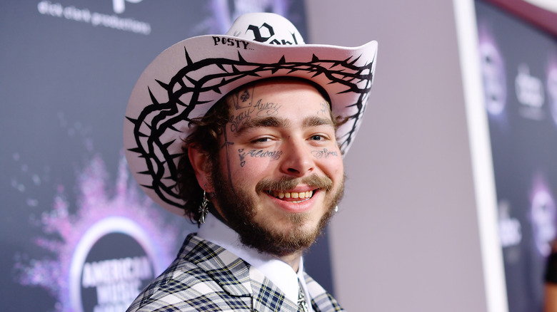 Post Malone portant un chapeau de cow-boy, souriant