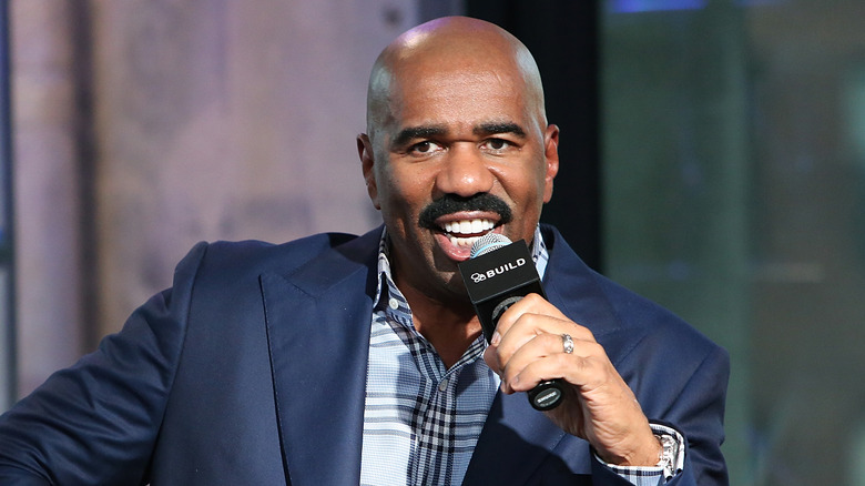 Steve Harvey tenant un microphone, parlant