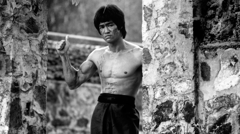 Bruce Lee posant, levant le pouce