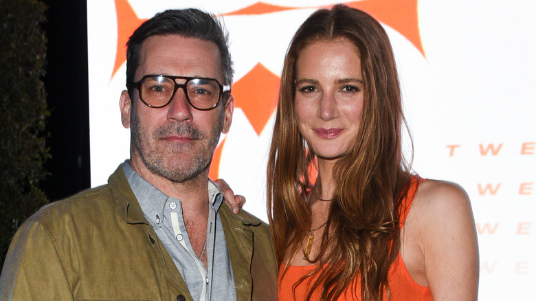 Jon Hamm à lunettes et Anna Osceola en robe orange