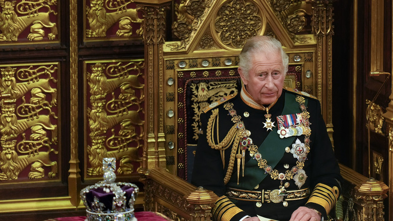 Le roi Charles est assis à côté d'une couronne