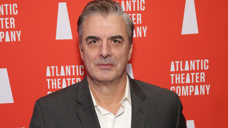 Chris Noth en costume gris, posant