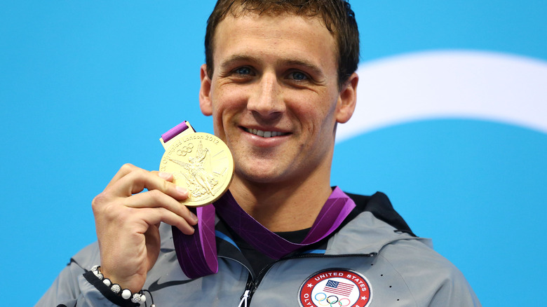 Ryan Lochte posant avec sa médaille d'or