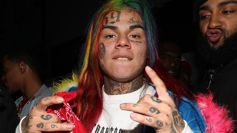 Tekashi 6ix9ine posant tenant un bandana rouge