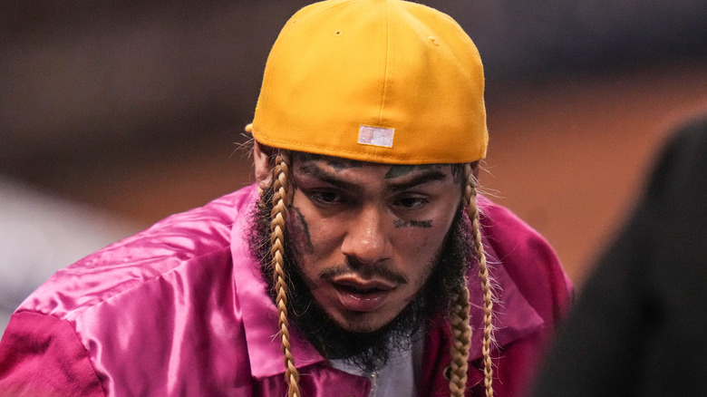 Tekashi 6ix9ine portant un chapeau violet et une casquette jaune