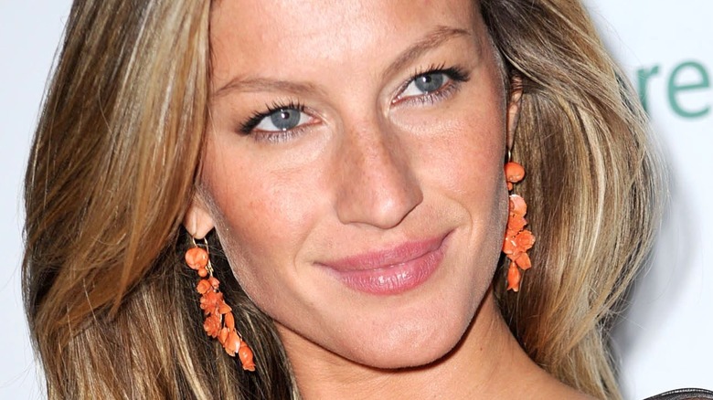 Gisele Bundchen boucles d'oreilles orange souriantes