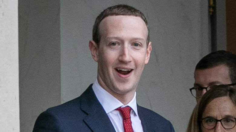 Mark Zuckerberg en cravate rouge souriant